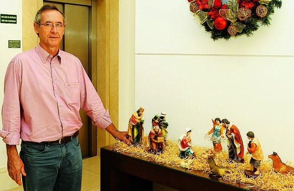 O s&iacute;ndico do Cambu&iacute; Garden, Paulo Wolf Filho, ao lado do pres&eacute;pio montado no residencial (Cesar Rodrigues/ ANN)