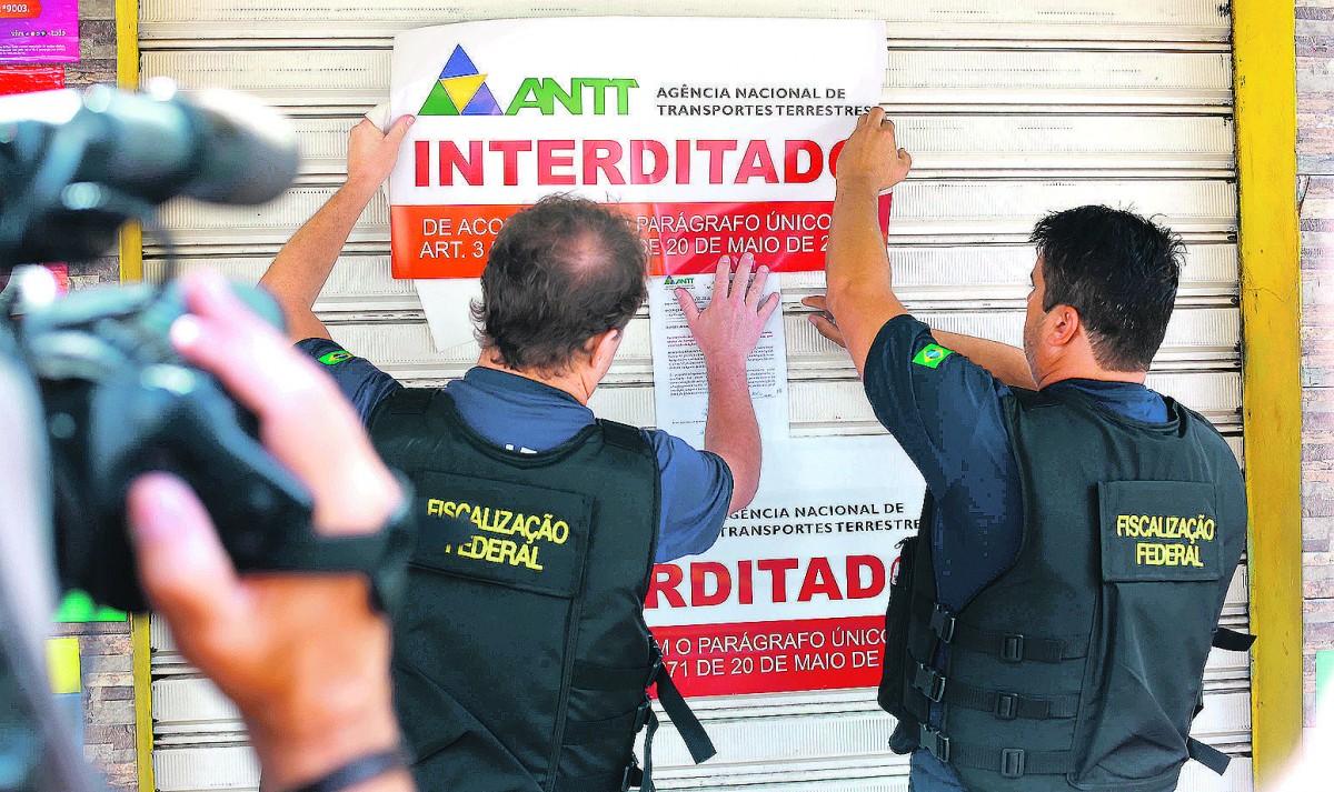 Fiscais da ANTT colam cartaz de "interditado" na porta de agência clandestina, em Campinas: viagens irregulares submetem passageiros a riscos  (Leandro Ferreira/AAN)