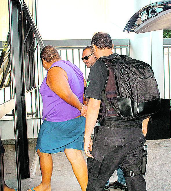 Policiais conduzem suspeito que estava com fotos e vídeos de crianças e adolescentes em cenas de abuso sexual (Divulgação)