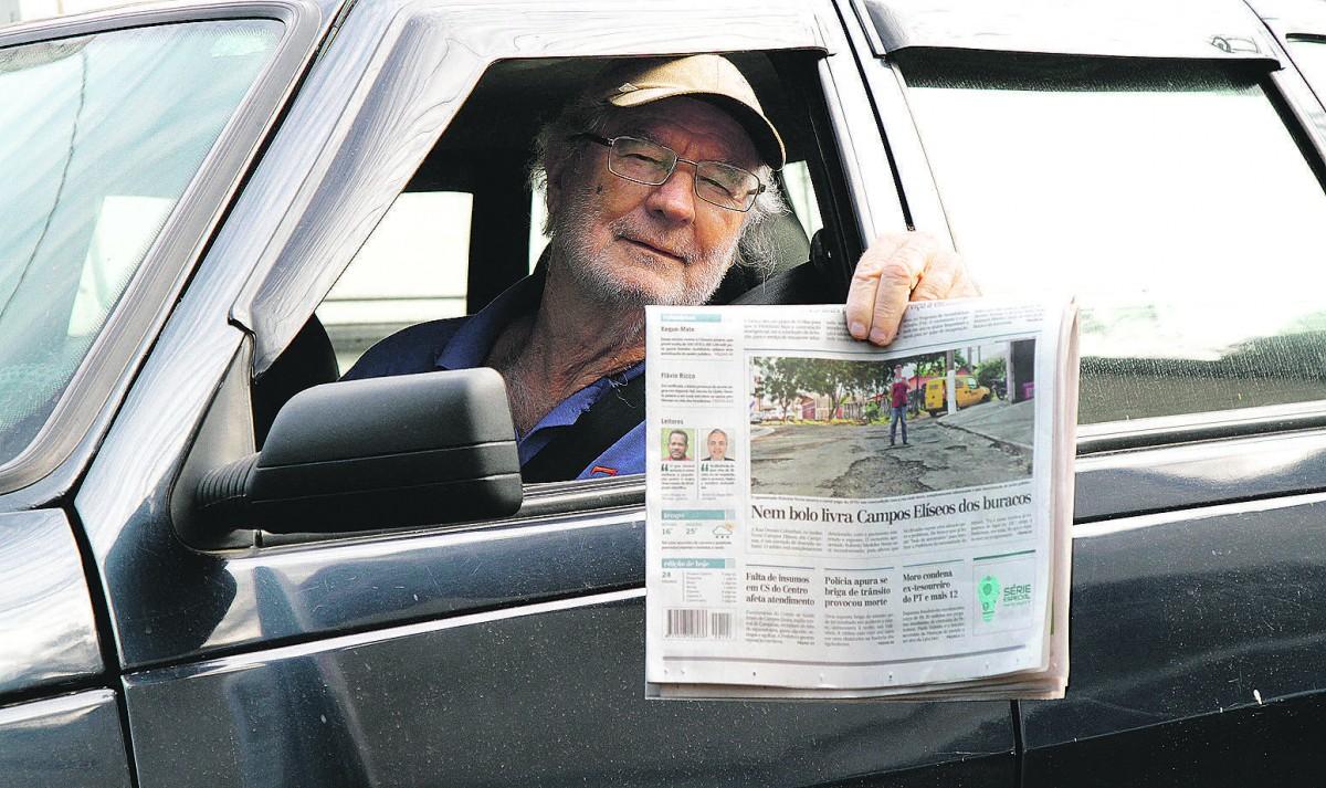 Roberto Merkiles mostra reportagem do Correio na qual reclamou do estado de abandono da Rua Orestes Colombari; "Vou guardar", promete ele  (Thomaz Marostegan/Especial para a AAN)