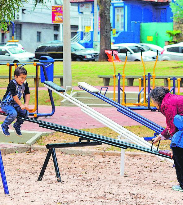 Mãe brinca com as crianças no renovado playground do Largo São Benedito, uma das áreas públicas de lazer mais tradicionais de Campinas (Carlos Bassan/PMC/Divulgação)