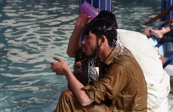 Paquistan&ecirc;s se refresca com copo d&aacute;gua em onda de calor que matou quase 200 pessoas no Pa&iacute;s (France PRess)