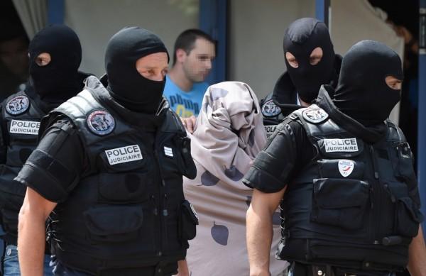 Policiais conduzem suspeito de ataque (  AFP)