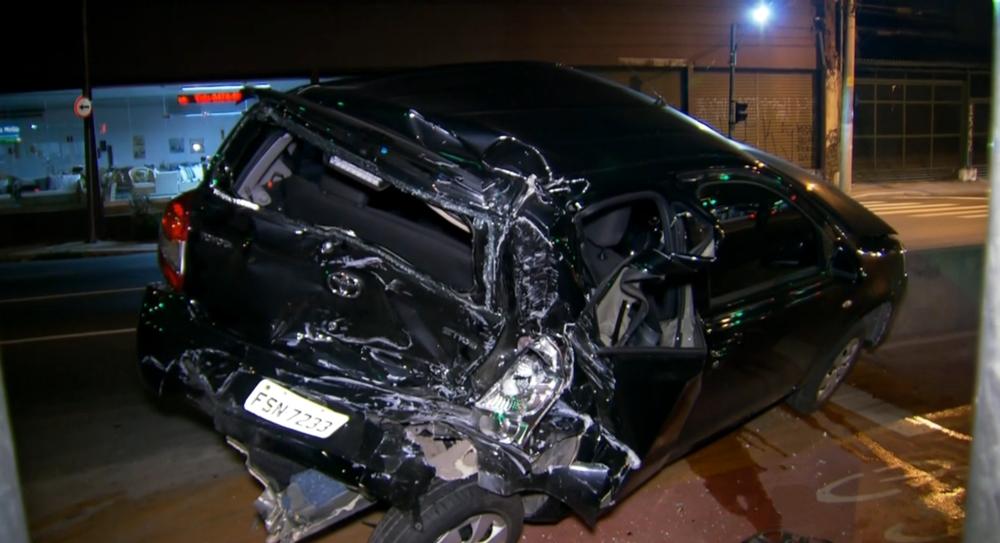 Carro preto &eacute; um dos quatro atingidos por carreta; foi parar em cima de mureta (Captura de vídeo/TV Globo)