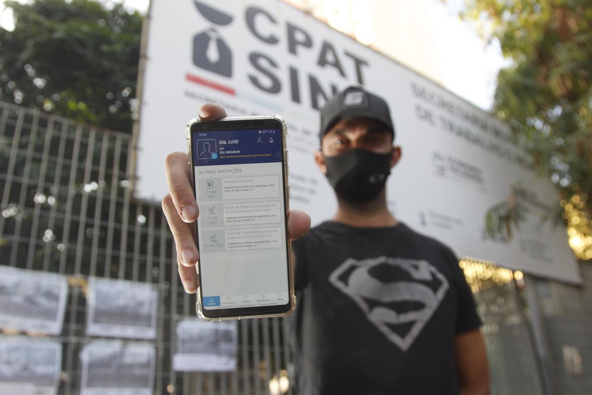 Trabalhador exibe a sua Carteira de Trabalho Digital no celular, em frente ao CPAT Campinas, no Centro (Ricardo Lima)