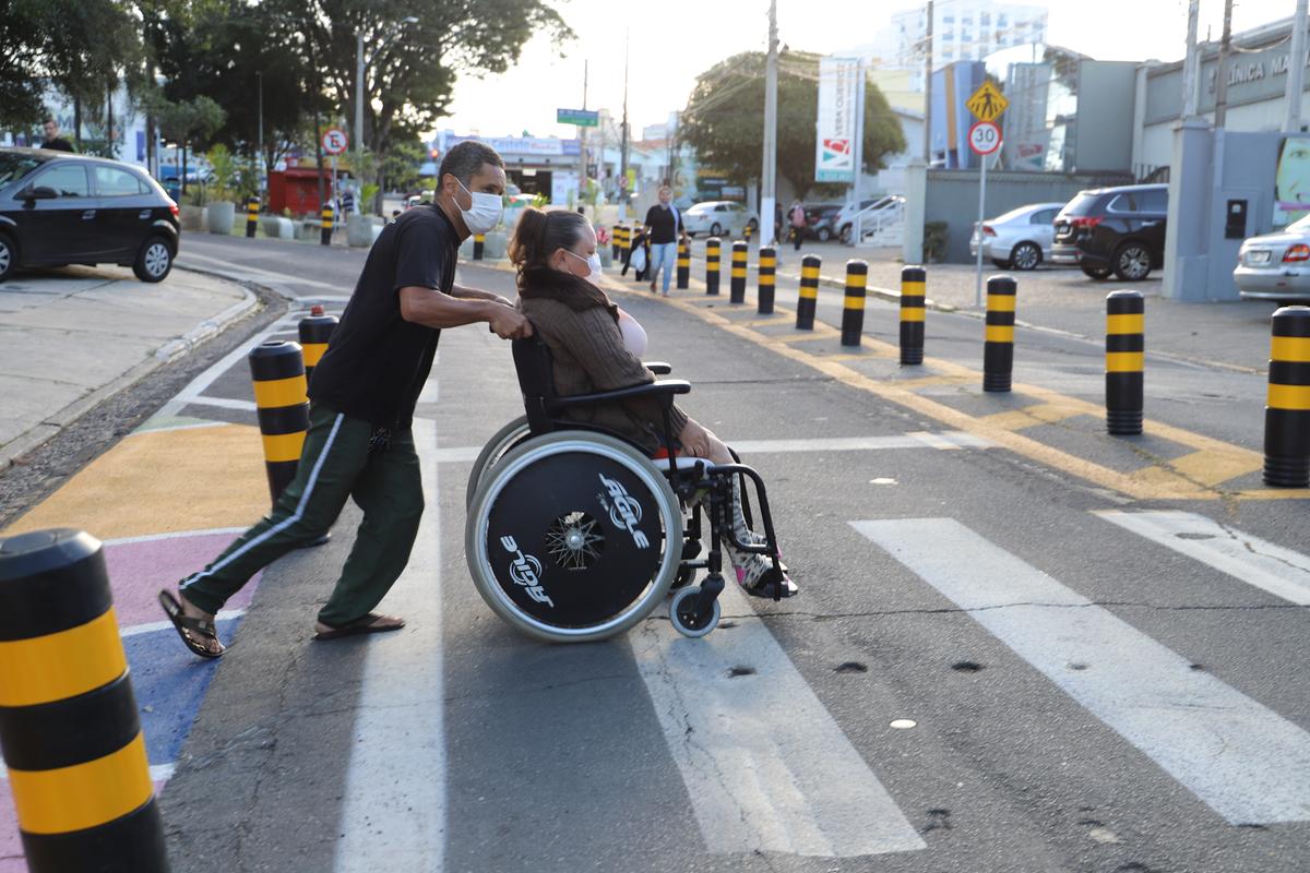 José Antônio Teodoro Davini atravessa a Rua Delfino Cintra com a mãe em uma cadeira de rodas: "A via ficou mais estreita, dá uma sensação de atravessar mais rápido” (Dominique Torquato)