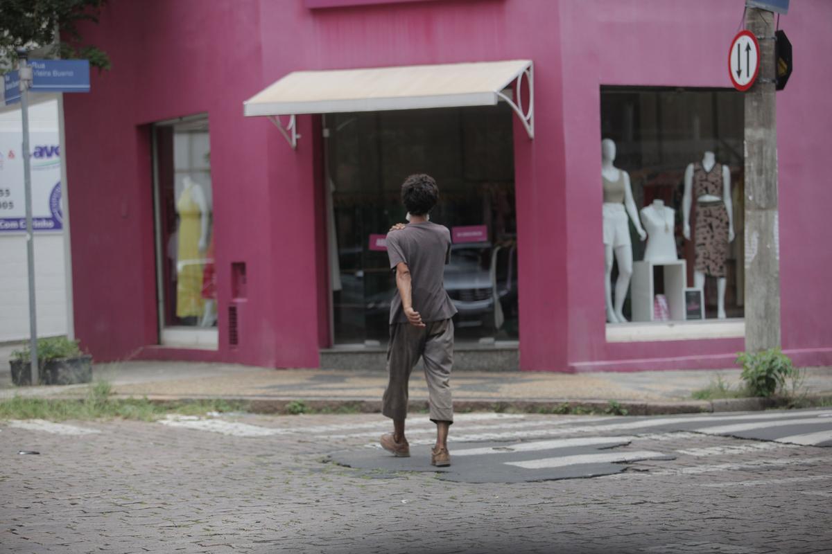 Morador de rua atravessa via no Centro: é preciso a união de setores públicos e população para reduzir o contingente de pessoas em situação de vulnerabilidade (Kamá Ribeiro)