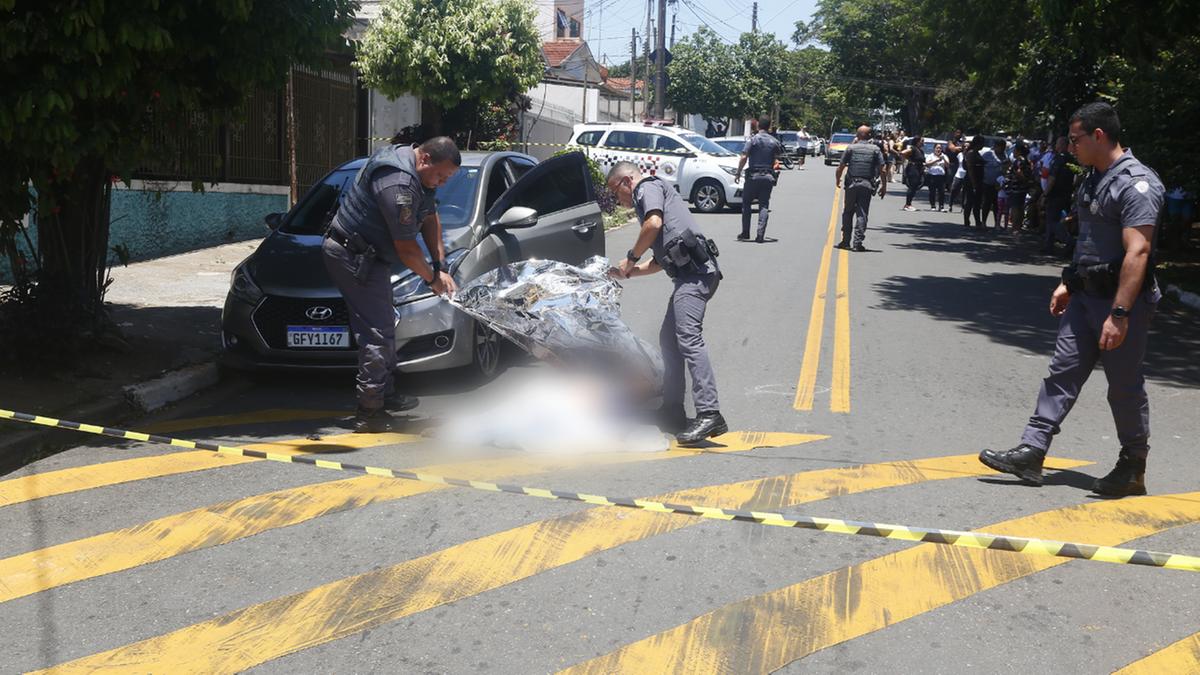 Policiais militares cobrem o corpo da vítima no local da execução: um suspeito foi preso com uma pistola 9mm (Gustavo Tilio)