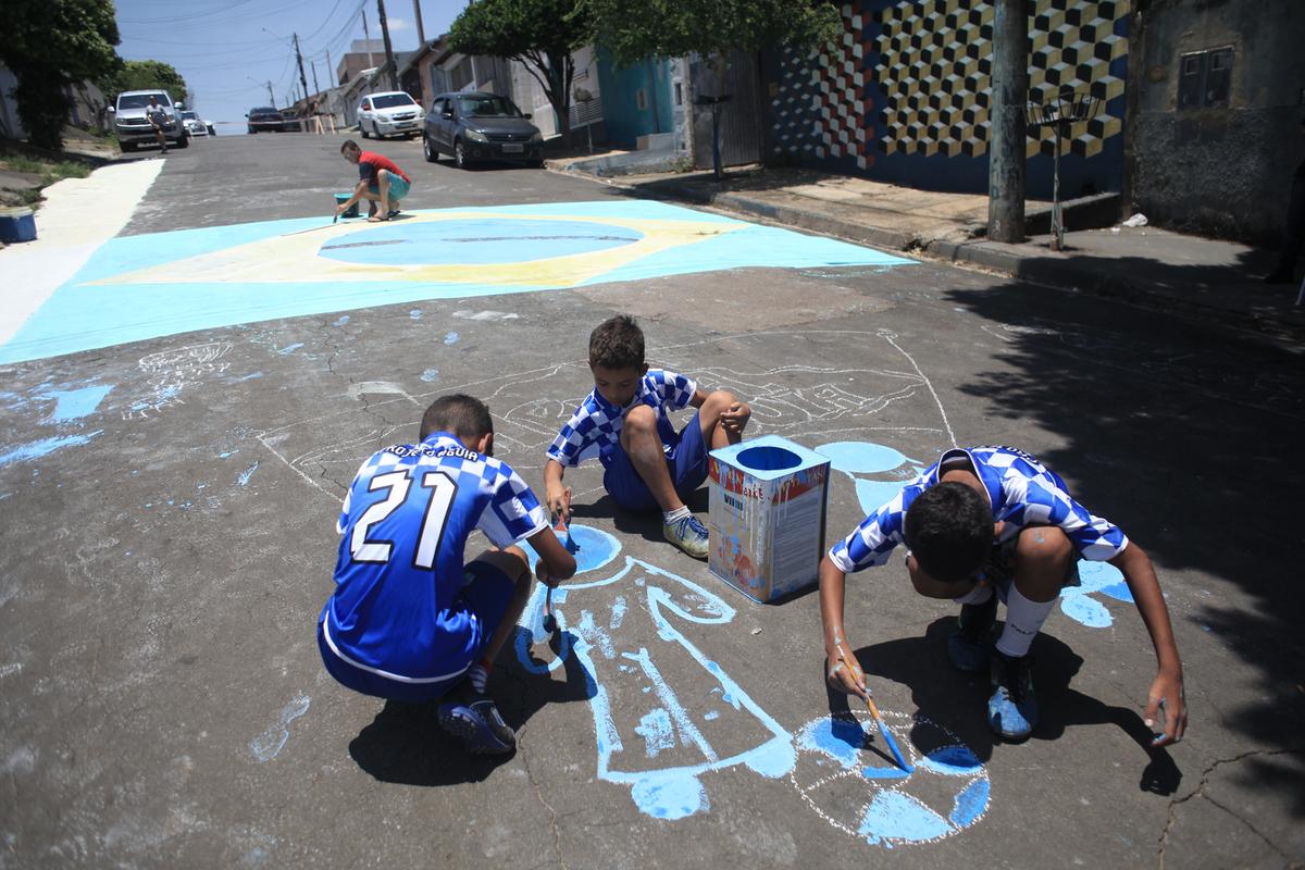 Garotada literalmente “pintou e bordou” durante a atividade de colorir desenhos na rua em alusão à Copa doMundo (Kamá Ribeiro)