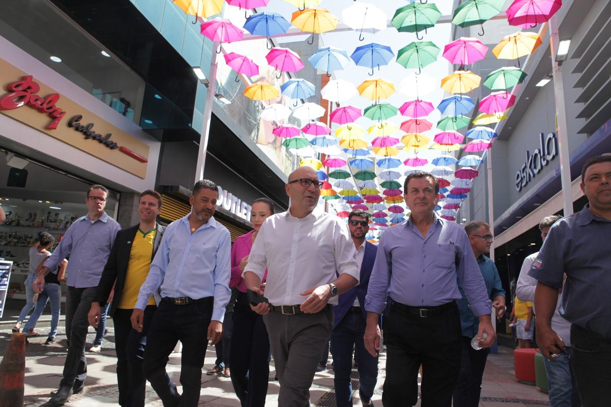 O prefeito Dário Saadi caminhou ontem sob a cobertura de guarda-chuvas no calçadão da Rua 13 de Maio (Rodrigo Zanotto)