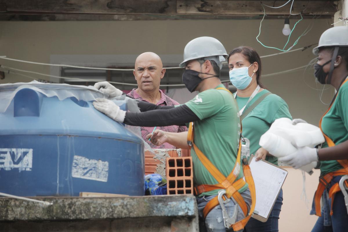 Equipe de controle da dengue instala tela de proteção contra o mosquito transmissor da doença em caixa d’água residencial (Kamá Ribeiro)