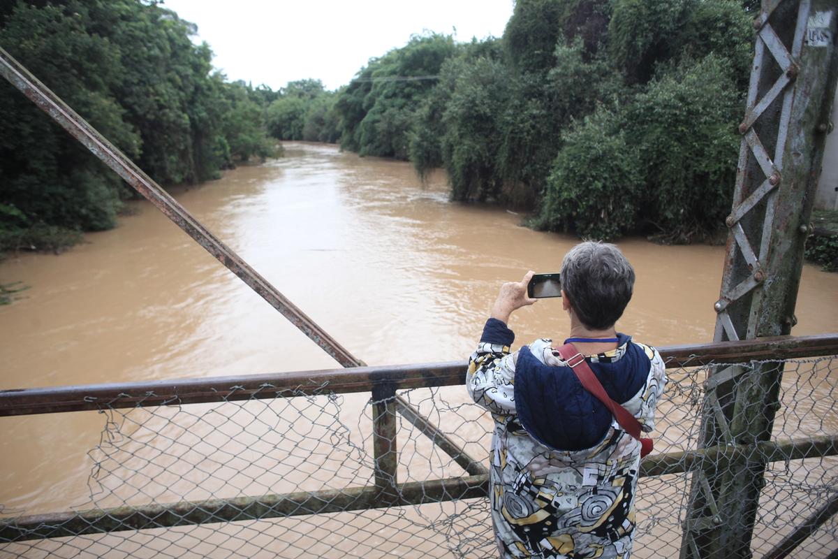 Mulher aproveita para tirar uma foto do Rio Atibaia cheio: até o final da tarde de ontem, 18 setores do município ainda eram monitorados de perto pela Defesa Civil de Campinas (Kamá Ribeiro)