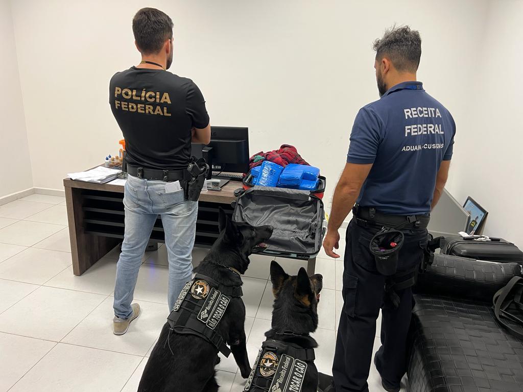 Agentes federais observam material apreendido durante operação de combate ao tráfico de drogas (Divulgação/ PF)