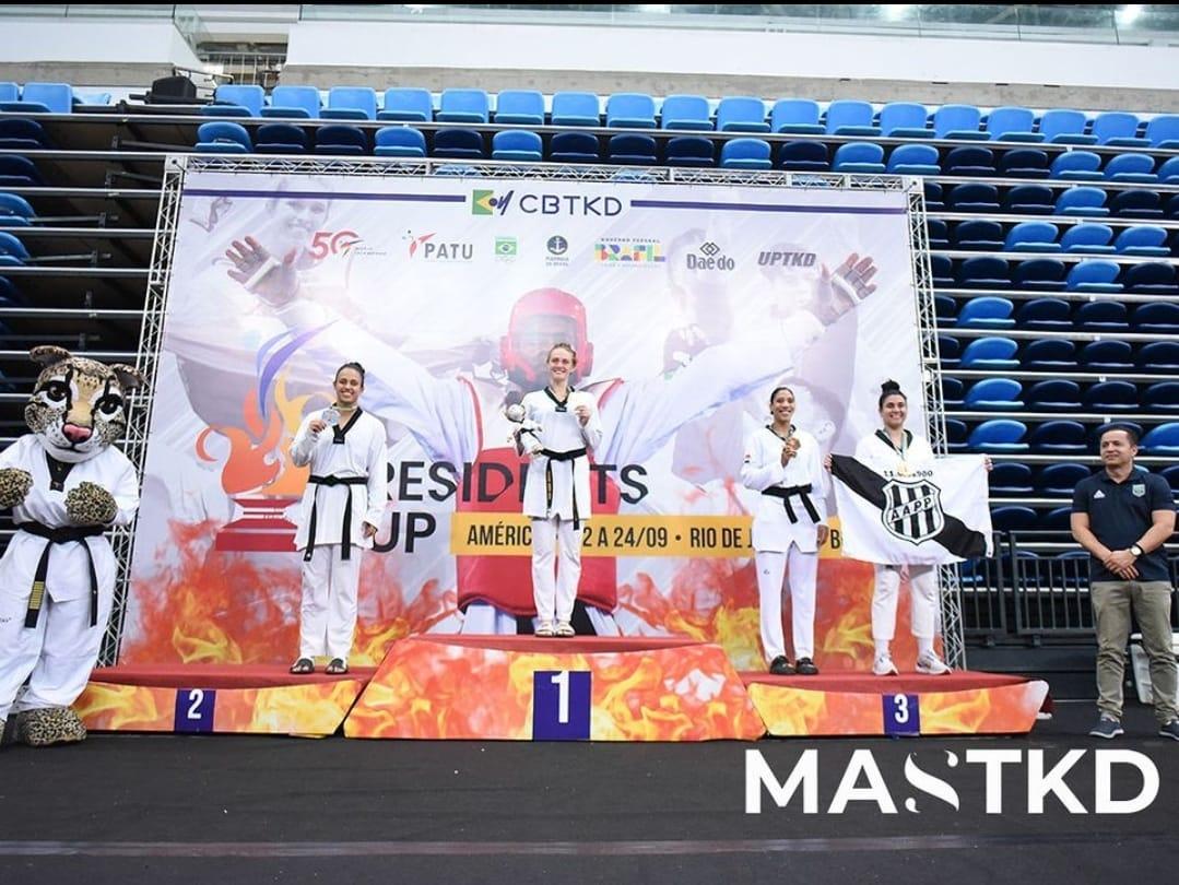 A atleta de taekwondo Larissa Pirola exibe a bandeira da Ponte Preta no pódio de competição internacional, em setembro (Divulgação)