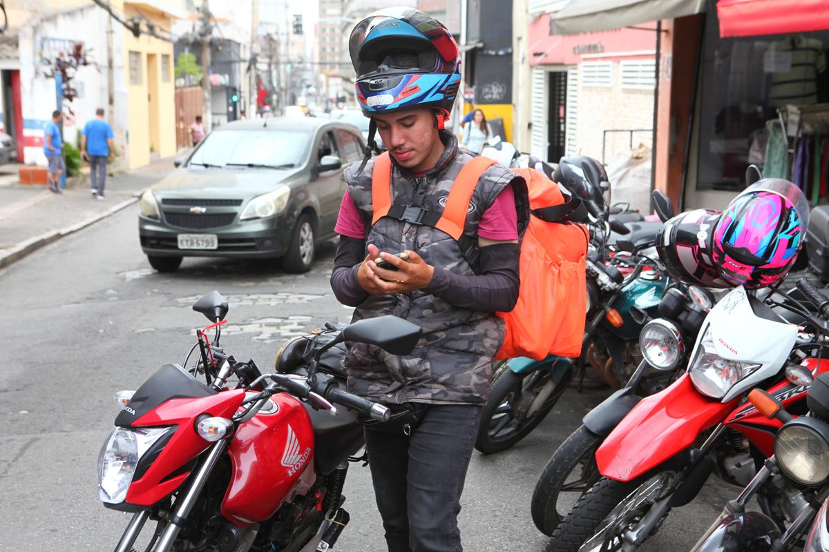 O motoboy João Pedro faz dupla jornada, trabalhando de dia como mototaxista e à noite como entregador em um estabelecimento (Rodrigo Zanotto)