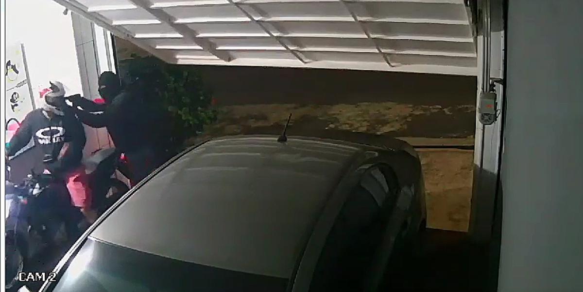 Momento em que os criminosos atacaram a vítima enquanto ela entrava de moto na garagem de sua casa (Divulgação)