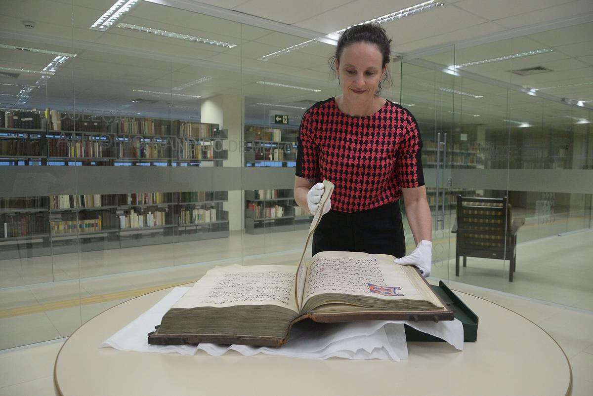 Danielle Ferreira, coordenadora técnica da Biblioteca de Obras Raras Fausto Castilho, manipula livro de canto litúrgico medieval, que seria de 1.430: maior foco da unidade são coleções de livros e estudos sobre o Brasil (brasiliana) (Alessandro Torres)