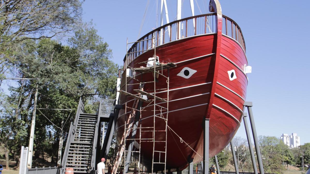 Um funcionário da Prefeitura de Campinas realiza reparos na parte externa da Caravela da Lagoa do Taquaral; na foto à esquerda, é possível ver o lado da embarcação que já recebeu uma nova pintura. Após a conclusão dos trabalhos, a Caravela será reaberta à visitação de sexta-feira a domingo, das 9h às 17h (Denny Cesare)