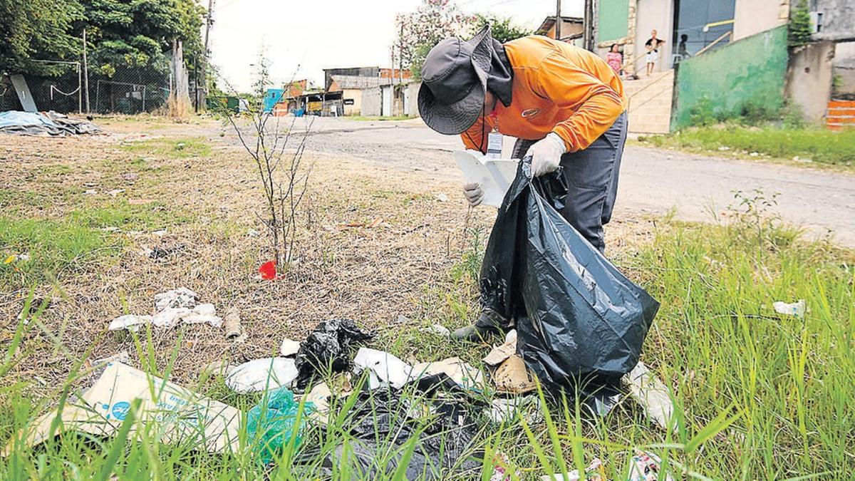 De camiseta laranja, agentes da empresa responsável pelo controle de criadouros precisam do auxílio da população no combate à dengue; no ano passado, 52% dos imóveis estavam inacessíveis para as equipes (Kamá Ribeiro)
