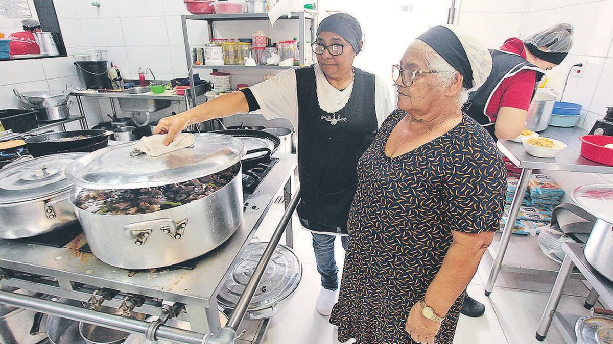 Antonia Ferreira Martins (primeiro plano) inspeciona a produção das refeições do dia na cozinha do seu restaurante; empreender foi a chave da evolução financeira da família (Rodrigo Zanotto)