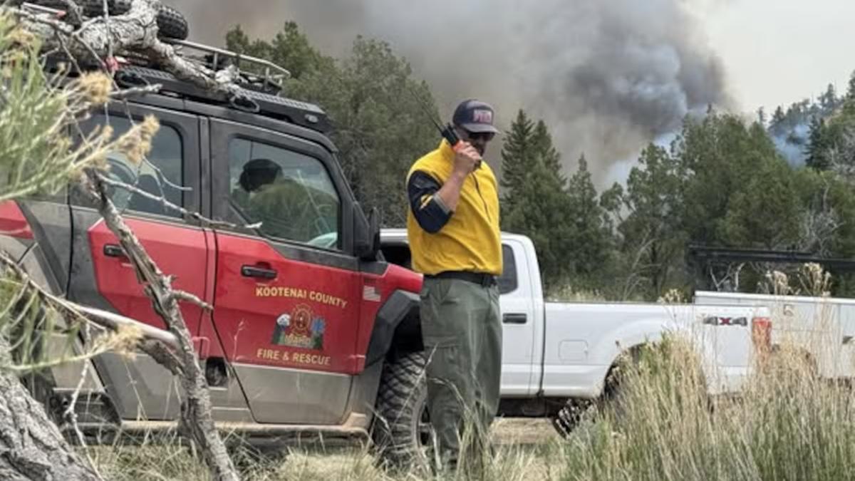 Trabalhador em frente a veículo do Corpo de Bombeiros de Kootenai, em Idaho (Estados Unidos), em região próxima a incêndio em foto publicada em 28 de junho de 2025 (@KootenaiCountyFireandRescue via Facebook)