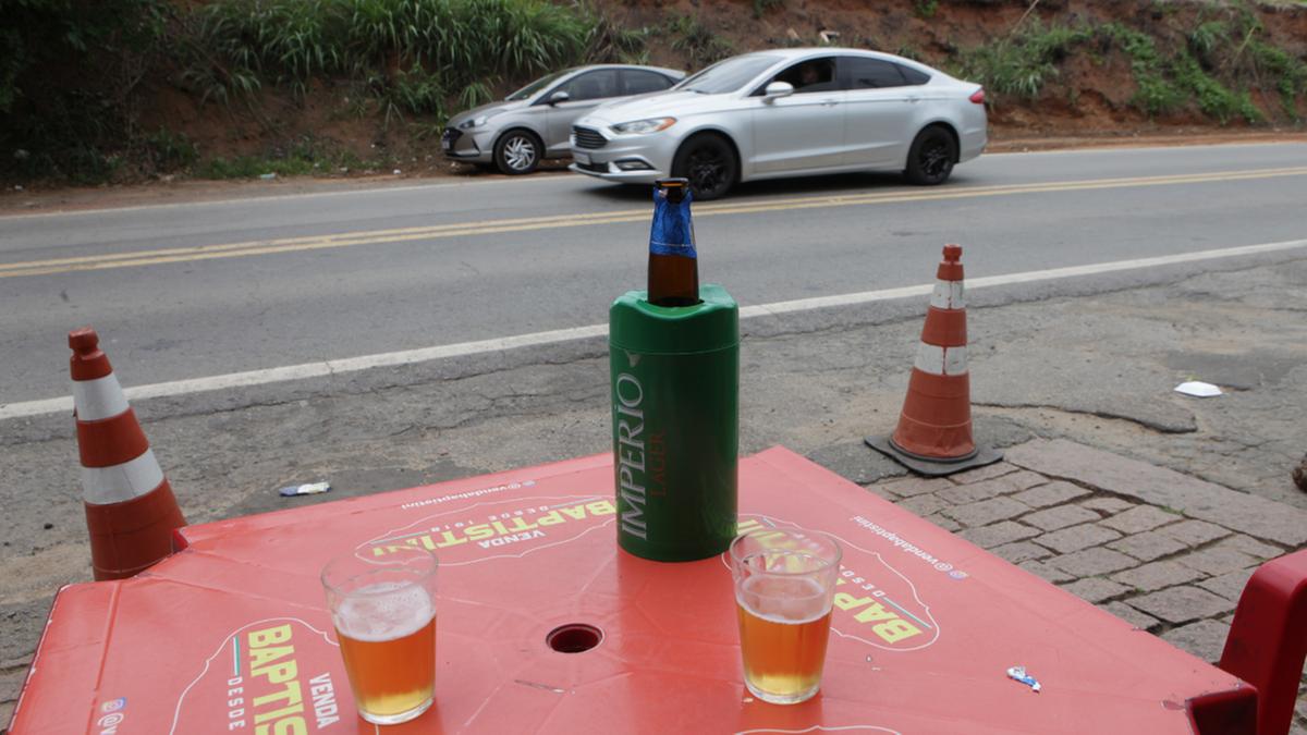 Clientes de bar instalado às margens da Rodovia Lix da Cunha tomam cerveja tranquilamente, enquanto observam o movimento na estrada (Rodrigo Zanotto)