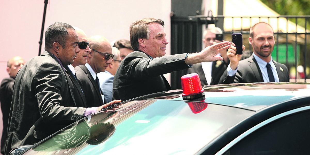 Cercado por seguranças, e ao lado do filho Eduardo, o presidente da República, Jair Bolsonaro, chega aos portões da EsPCEx para a solenidade de ingresso de novos alunos. (Ricardo Lima/ Correio Popular)