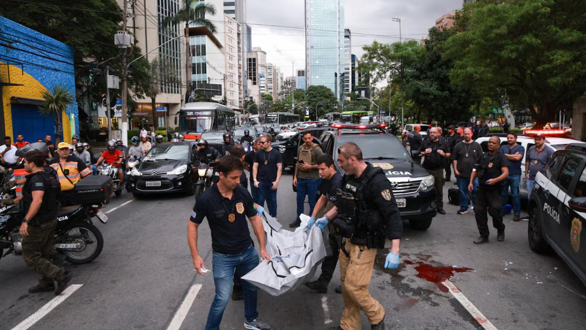 Policiais carregam corpo de suspeito morto; tiroteio interditou cruzamento das avenidas Faria Lima e Cidade Jardim (Daniel Teixeira/Estadão)
