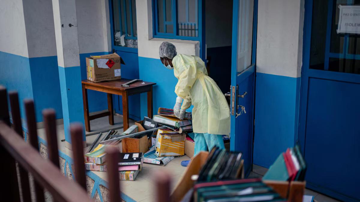 Profissional de saúde remove objetos e abre espaço para possíveis novas internações em hospital no Congo (Jospin Mwisha/AFP)