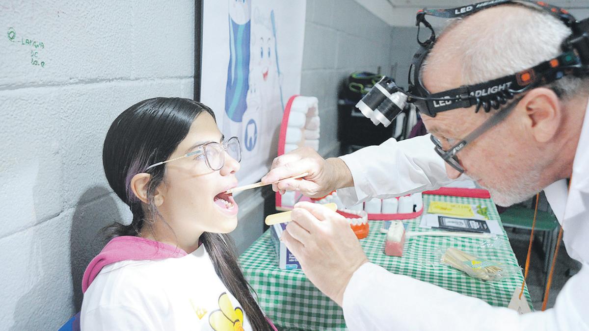 O exame da saúde bucal de alunos, pais e membros da comunidade foi um dos serviços oferecidos ontem na escola do Jardim Nilópoli (Matheus Reche)