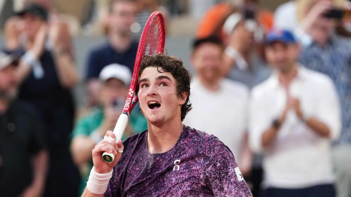 O brasileiro João Fonseca comemora após vencer o sérvio Novak Djokovic ao final da partida de simples masculina do sexto dia do torneio de tênis do Aberto da França, na quadra Philippe-Chatrier, no complexo de Roland-Garros, em Paris, em 29 de maio de 2026 (Dimitar DILKOFF/AFP)