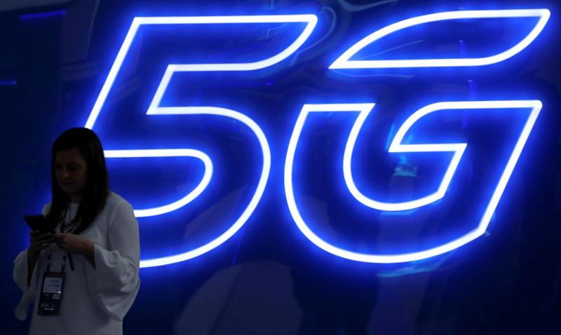 FOTO DE ARCHIVO: Una mujer mira su teléfono móvil junto a un cartel de 5G en el Mobile World Congress en Barcelona, España, 25 de febrero de 2019. REUTERS/Sergio Pérez (REUTERS/Sergio Perez)