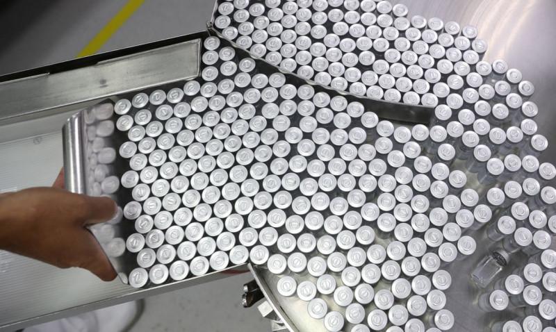 An employee puts on an equipment vials containing CoronaVac, Sinovac's vaccine against the coronavirus disease (COVID-19), at Butantan biomedical production center in Sao Paulo, Brazil January 22, 2021. REUTERS/Amanda Perobelli (REUTERS/Amanda Perobelli)
