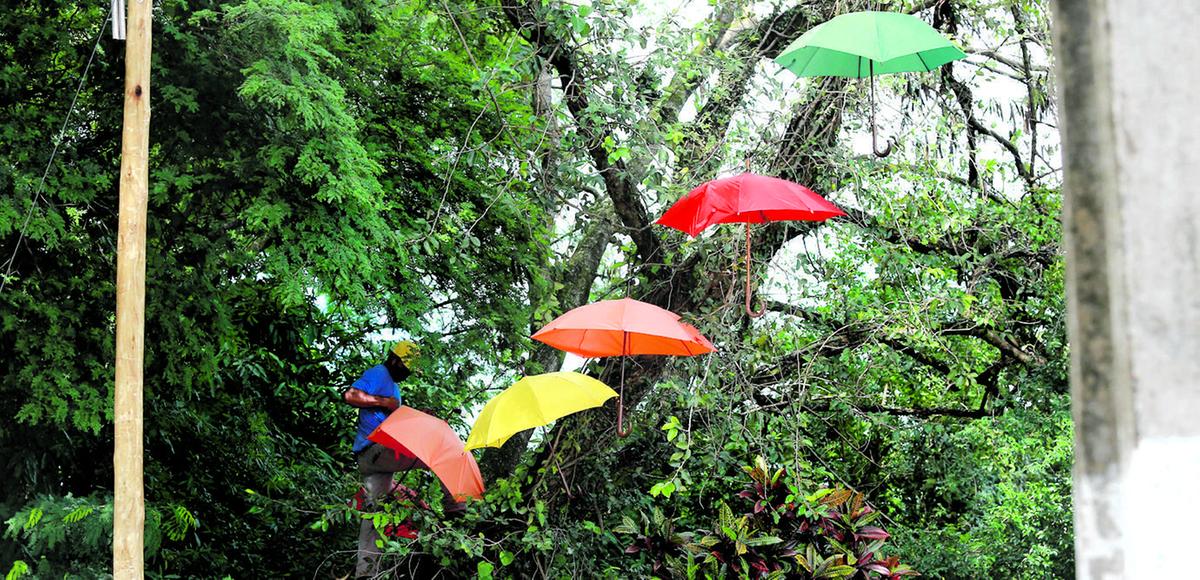 Funcionário faz manutenção em varal de guarda-chuva em Holambra: um visual colorido de uma cidade florida (Leandro Ferreira/AAN)