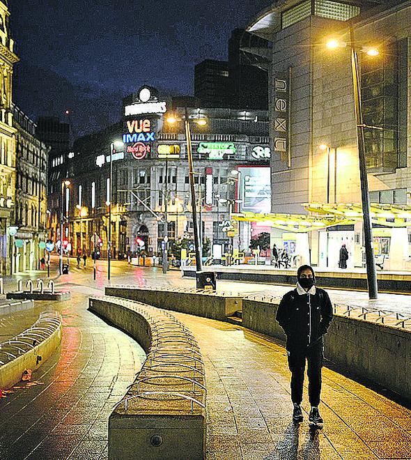Homem caminha por rua praticamente deserta em Manchester, na Inglaterra: um novo e longo confinamento (Oli Scarff/AFP)