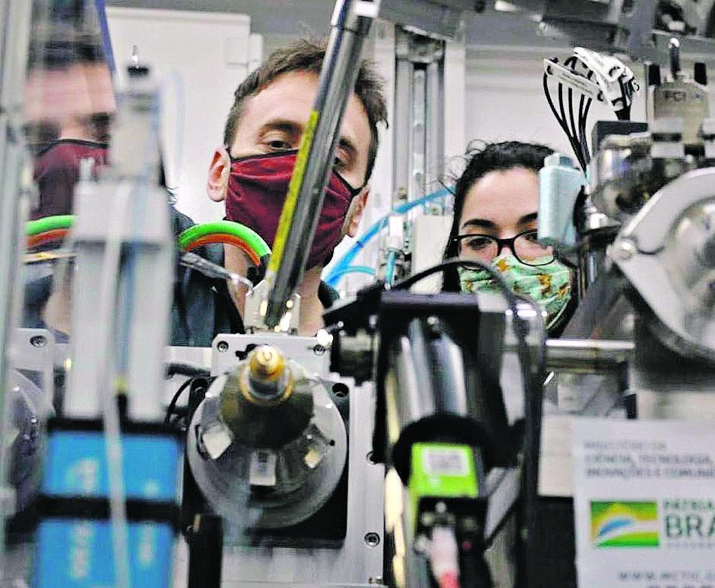 André Godoy e Aline Nakamura posicionam cristal de proteína de SARS-CoV-2 para análise no acelerador (Divulgação)