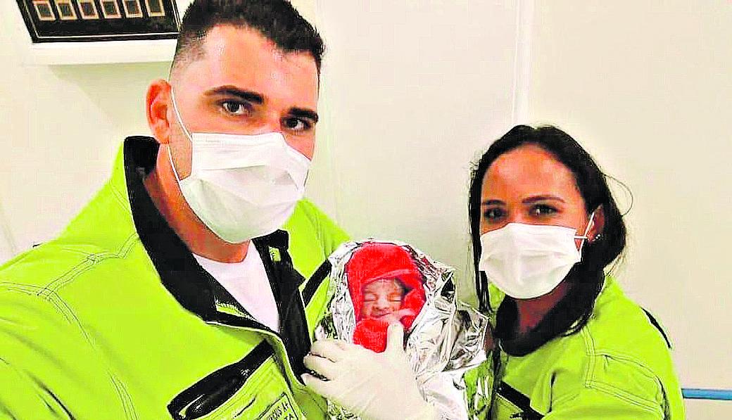 Marcus e Ednalda seguram o bebê que ajudaram a vir ao mundo no acostamento da Santos Dumont (Divulgação)