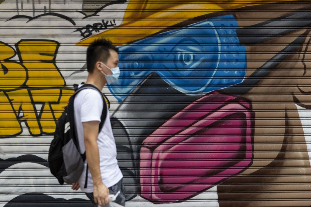 Homem usando máscara caminha pelas ruas em Hong Kong (AFP)