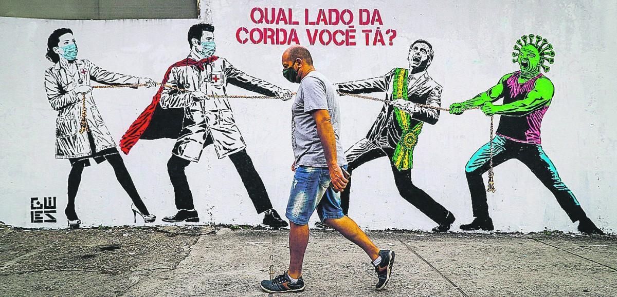 Grafite do artista Guiles, na Barra Funda, em São Paulo, retrata a disputa entre a ciência e Bolsonaro (ALOISIO MAURICIO/ESTADÃO CONTEÚDO)