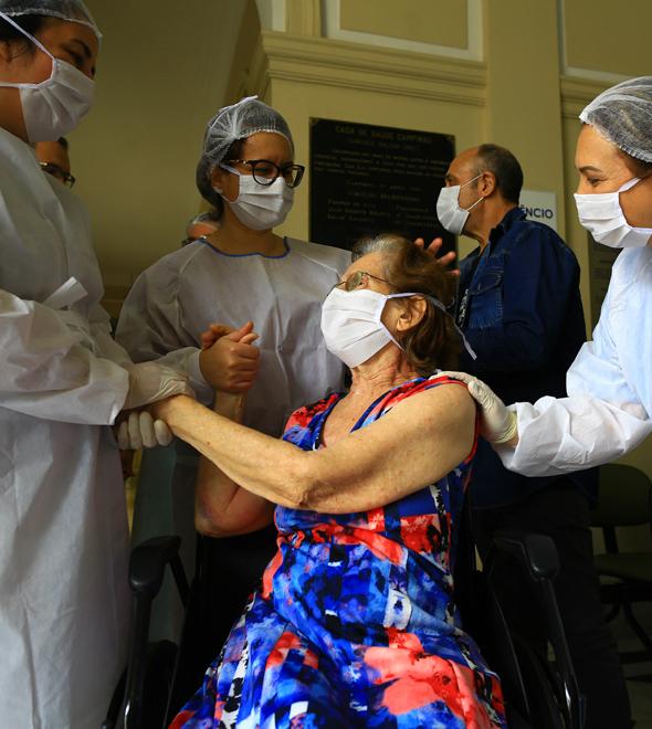A paciente Neiva Ferraro Mostasso Camacho recebe carinho de membros da equipe do Vera Cruz no dia da sua alta hospitalar: 15 dias internada (Leandro Ferreira/AAN)