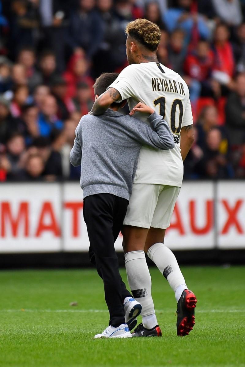 Torcedor invadiu o campo no final do duelo para abraçar Neymar, que não fez gol, mas teve boa atuação na partida (AFP)