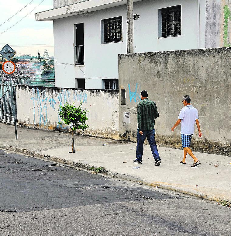 Homens caminham na calçada onde ficava o ponto: desaparecimento (Matheus Pereira/Especial para a AAN)