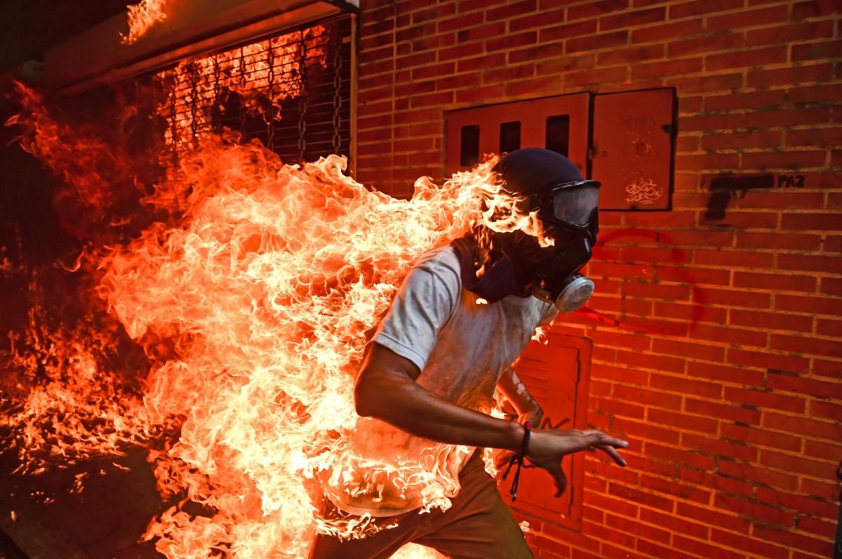 Na foto, Víctor Salazar, um estudante de 28 anos, queimava como uma tocha humana, após a explosão do tanque de gasolina de uma motocicleta militar (AFP)
