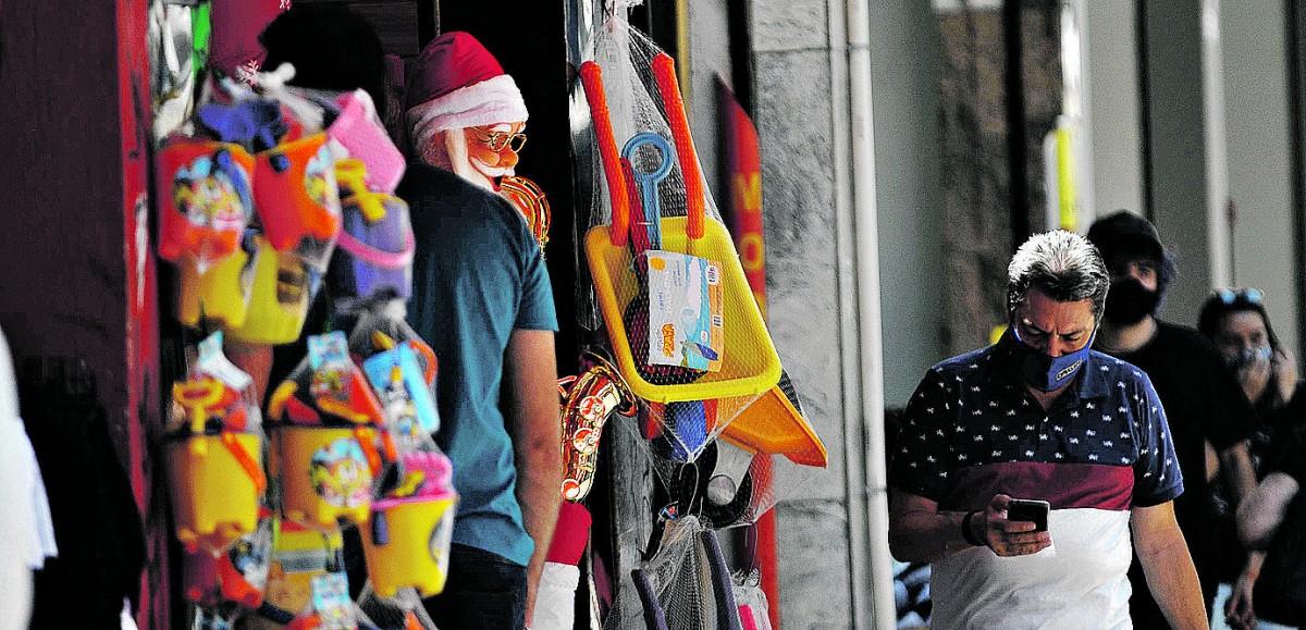No frenesi da metrópole, há espaço para conferir a notificação no celular, enquanto a decoração de Noel começa a sobressair (Wagner Souza/AAN)