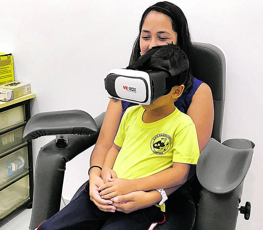 Ryan, de 5 anos, utiliza os óculos de realidade virtual no colo da mãe, a auxiliar administrativa Priscila Soares da Silveira: inovação aprovada (Divulgação)