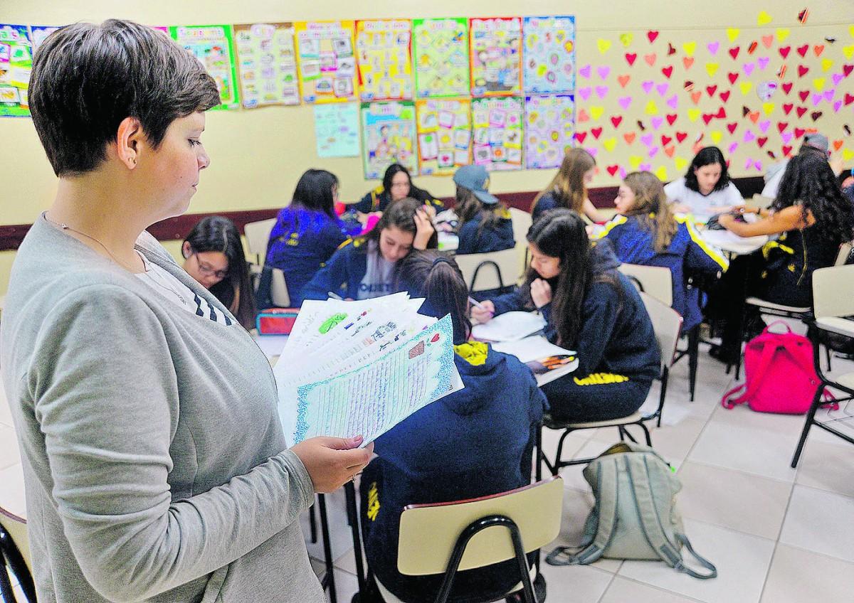 A professora Aline Bottcher Ferrarezi verifica o material feito pelos adolescentes: uma experiência que desperta o hábito da escrita e a cidadania (Patrícia Domingos/AAN)