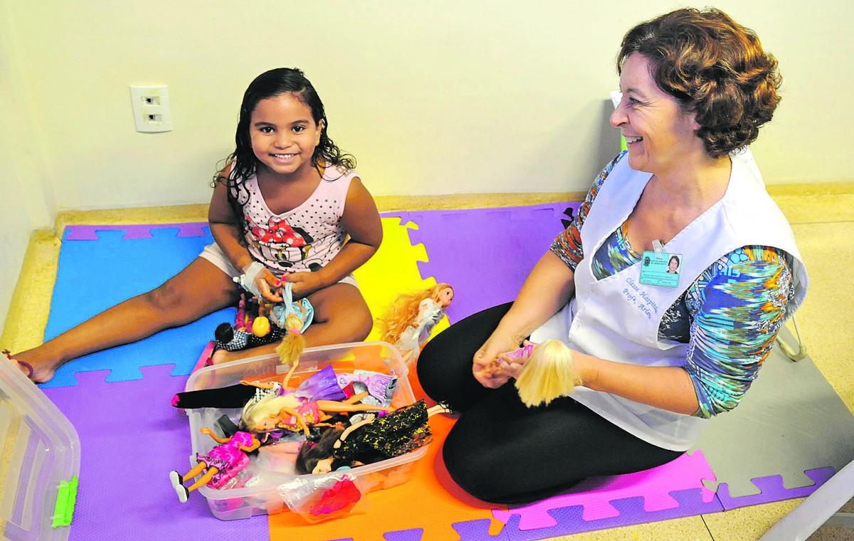 Professora Arlene Machado com a paciente Pâmela da Silva na Classe Hospitalar: brincadeiras auxiliam no principal objetivo, que é pedagógico (Dominique Torquato/AAN)