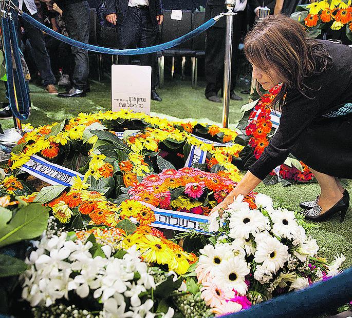 Mulher coloca flores no túmulo de Shimon Peres depois do enterro  (Menahem Kahana/AFP)