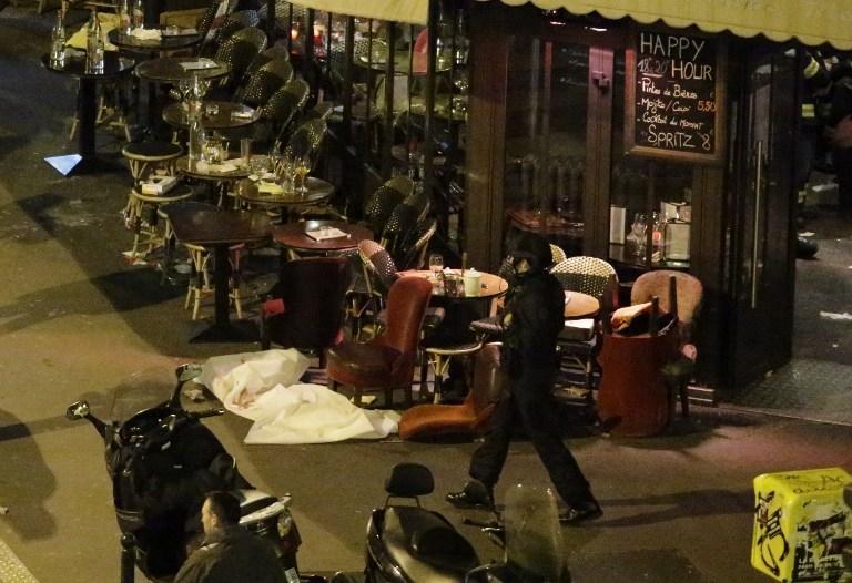 Um corpo é coberto com lençol branco em café no Centro de Paris, onde ocorreram ataques terroristas no dia 13 de novembro de 2015 (France Press )