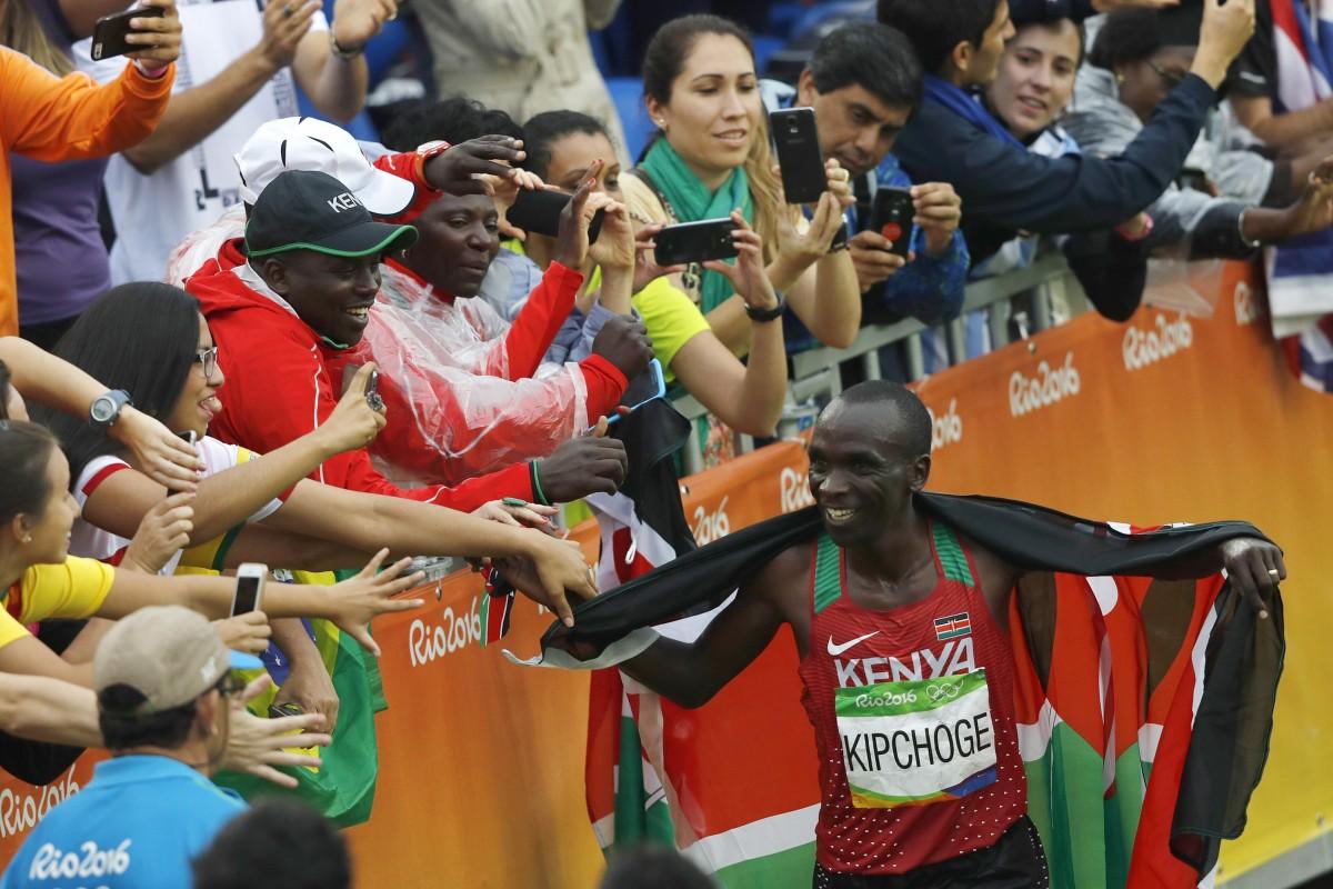 O queniano Eliud Kipchoge recebe o carinho do público após vencer a maratona olímpica (Adrian Dennis/France Press)